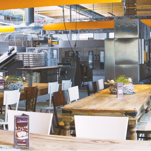 Blick aus dem Backstubencafé mit Sitzgelegenheiten in die Schau-Bäckerei